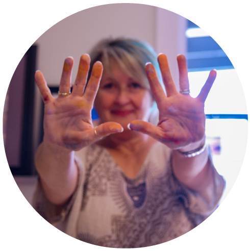 andrea showing her hands covered in pastel dust